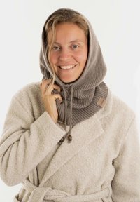 Gebreide grijze col sjaal met een capuchon, met gebogen textuur, trekkoordsluiting en een merklabel. Draagt over een lichtbeige jas.