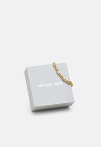 Pilkas papuošalų dėžutė su tekstūruotu paviršiumi. Viršuje pritvirtinta auksinė grandinėlė. Matoma ženklas: "MICHAEL KORS" balta spalva.