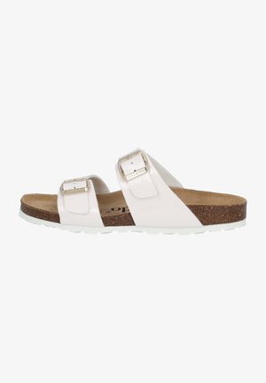 Sandalia blanca de dos tiras con hebillas metálicas ajustables, plantilla de corcho y suela de goma texturizada. Material exterior suave con acentos mínimos.