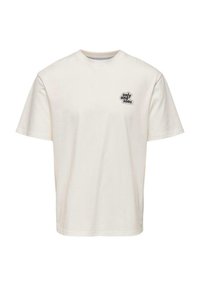 T-shirt à manches courtes en coton crème avec un col rond et un petit patch logo noir sur la poitrine gauche. Design simple, sans motifs.