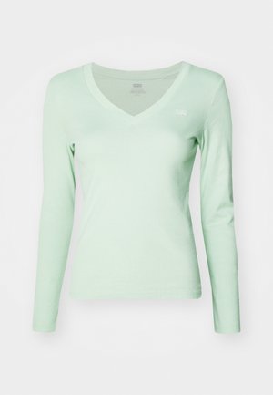 Top verde deschis cu mânecă lungă și decolteu în V, fabricat dintr-un material moale, având o croială ajustată și un logo mic pe pieptul stâng.