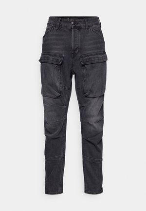Svarte cargo-bukser laget av denim, med flere frontlommer, tettsittende passform, svak falming og sømdetaljer langs beina.