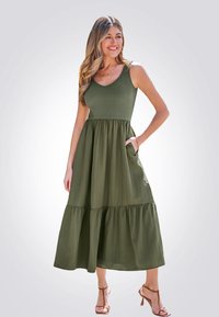 Olijfgroene, mouwloze maxi-jurk met een aansluitende torso en een uitlopende, gelaagde rok. Geribbelde textuur en zijzakken.