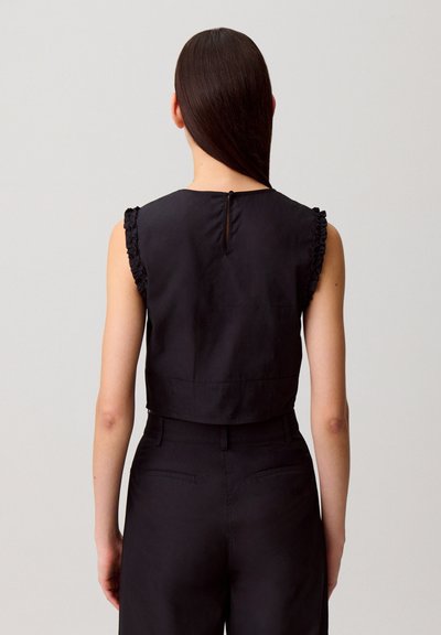 Top nero cropped senza maniche con una texture liscia e spalline arricciate, con un'apertura a goccia sul retro.