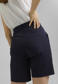 Pantalones cortos azul marino con un corte entallado, que presentan una textura suave, dos bolsillos traseros y una cintura de media altura.