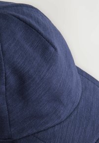 Mörkblå keps i texturerad tyg, med sydda paneler och en böjd skärm, med en slät finish och utan synlig märkning.