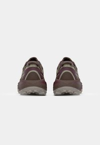 Scarpe da trail running con un design marrone scuro e borgogna, upper in rete, suola in gomma testurizzata e supporto per il tallone rinforzato.