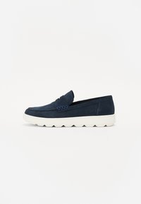 Blå fløyels slip-on sko med hvit gummisåle, med en hevet aksentbånd og minimalistisk design. Glatt tekstur, klassisk form.