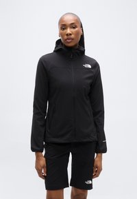 Μαύρο μπουφάν με φερμουάρ και κουκούλα, με δύο πλαϊνές τσέπες, κατασκευασμένο από λείο ύφασμα. Συνδυάζεται με μαύρα σορτς που έχουν λογότυπο στο τελείωμα.