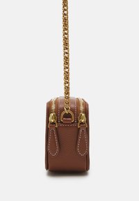 Mini bag in pelle marrone con hardware dorato, zip superiori e finitura testurizzata. Presenta una tracolla a catena e cuciture a contrasto sui lati.