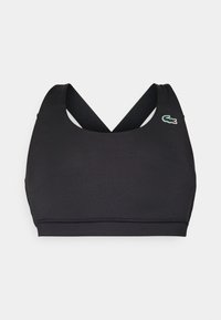 Svart sportbh med rundad halsringning, korslagda axelband och en liten Lacoste-logotyp i grönt, rött och vitt. Slät tygkvalitet.