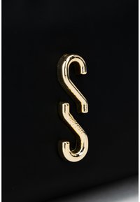 Zlatá S-krivková spona na čiernom pozadí, ktorá predvádza štýlový detail tašky alebo dizajnu doplnku.