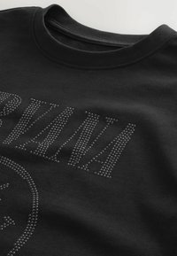 Black sweatshirt featuring a crew neckline and rhinestone detailing spelling "NIRVANA" with a round logo design accent. Soft fabric texture.