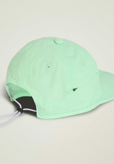 Gorra de béisbol verde menta con cierre ajustable de cordón y pequeño detalle metálico en el lateral, mostrada desde atrás y en ángulo lateral.