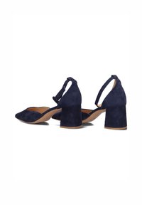 Navy blue suede block-heeled shoes with a pointed toe and slingback strap. The texture is soft with a smooth interior lining.