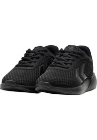 Paire de chaussures de sport noires avec une texture en mesh, des lacets noirs et des logos chevrons subtils sur les côtés et la languette.