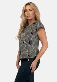 Krótki rękaw z czarnym tłem i białymi wzorami liści. Wykonany z lekkiego materiału, z luźnym krojem i okrągłym dekoltem.