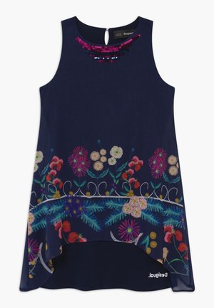 Marineblå ærmeløs kjole med blomsterprintkant, palietudekoration ved halsen og høj-lav kantdetalje.