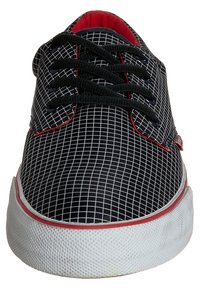Baskets noires avec un motif en damier, accents rouges, lacets noirs et une semelle en caoutchouc blanc. Texture lisse avec un design à bout rond.
