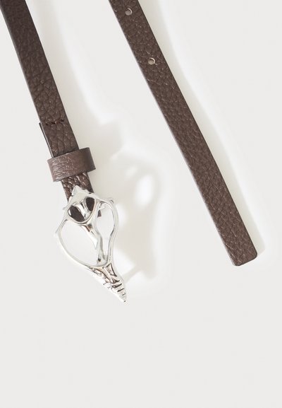Ceinture en cuir marron texturé avec une boucle en argent unique en forme de motif floral abstrait, posée à plat sur fond blanc.