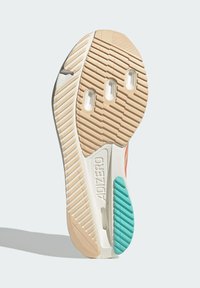 Suola di scarpa Adidas Adizero beige, bianca e teal con grip testurizzato e tre fori ovali vicino alla parte anteriore.