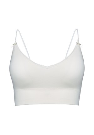 Biała bezszwowa braletka z cienkimi regulowanymi ramiączkami i małymi ozdobnymi kokardkami na górze każdego ramiączka.