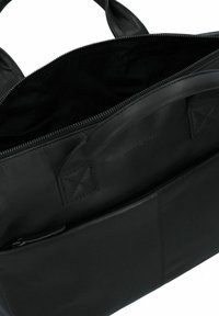 Zwarte leren tas met een gladde textuur, een ritsluiting en een groot hoofdcompartiment met een voorvak. Dubbele handvaten voor het dragen.