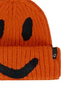 Berretto lavorato a maglia arancione con design di faccina sorridente nera. Tessitura a costine, risvolto e piccolo marchio sul lato.