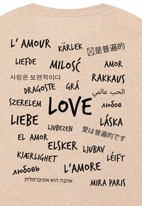 Il design della maglietta presenta la parola "AMORE" in varie lingue, circondata da termini correlati come "L'amour", "Amor" e "Liebe."