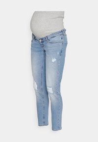 Jeans de maternidad de color azul claro con una cinturilla elástica gris y detalles desgastados en las piernas. Corte ajustado con tobillos ceñidos.