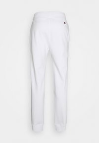 Vita svettbyxor med en tapered bendesign, elastisk midjeband och ribbade muddar. Liten logotypdetalj på baksidan. Mjuk bomullsblandning.