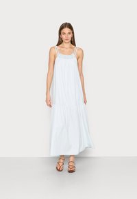 Vestido maxi azul claro feito de tecido macio, apresentando alças finas ajustáveis, decote franzido e um design de saia em camadas.