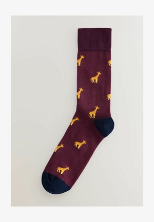 Burgundy sokid, millel on väike kollaste žiraffide muster, tumblue varba ja kandiga. Struktuurne kudum.