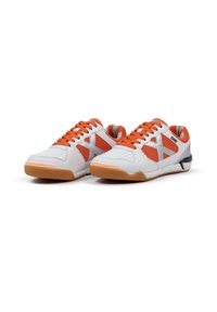 Zapatillas deportivas con una parte superior sintética blanca, paneles de malla naranja y cordones a juego, con una suela de goma y acentos en gris.