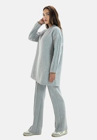 Grijze katoenen mix-outfit met een langwerpige tuniek met een licht afgeronde zoom en bijpassende loszittende broek met verticale naaddetails.