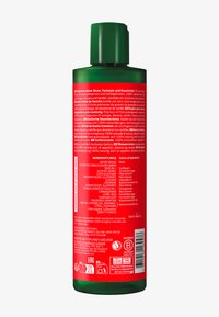 Bouteille en plastique verte avec un sommet arrondi, étiquette rouge présentant un texte blanc, énumérant les ingrédients et les informations sur le produit. Texture lisse, design ergonomique.