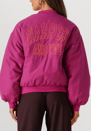 Fuchsia bomberjacket met oversized mouwen, geribbelde manchetten en de tekst "HARPER AND YVE" in vet oranje op de rug.