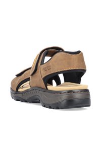 Sandale en cuir brun avec design ouvert, brides ajustables, semelle texturée et intérieur rembourré pour le confort. Présente le logo Rieker.