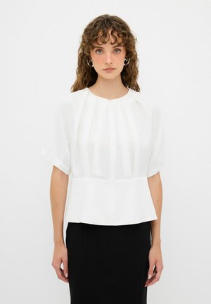 Blusa blanca de manga corta, con plisados verticales y escote redondeado, combinada con una falda negra ajustada. Tela suave y ligera.