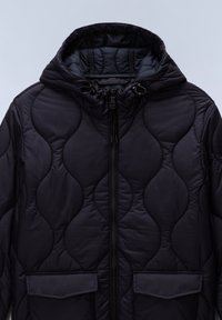 Svart quiltad jacka med huva, med dragkedja, två framfickor och ett vågigt sydd design för extra textur.