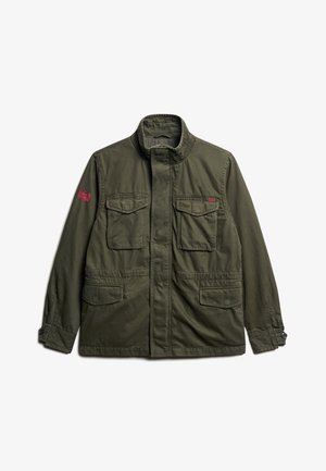 Giubbotto utilitario verde oliva realizzato in cotone con colletto rialzato, dotato di due tasche sul petto, tasche laterali e una toppa rossa sulla manica sinistra.