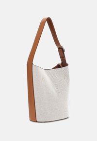 Beige canvas skuldertaske med en brun læderrem, der har en glat tekstur, enkel form og detaljer i guldfarvet metal.