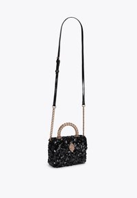 Borsa a tracolla nera con paillettes, dalla forma strutturata, con una maniglia dorata prominente e una tracolla removibile.