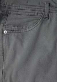 Pantaloni di tessuto grigio con una finitura liscia, dotati di una tasca frontale, cuciture a contrasto e un rivetto in metallo vicino alla tasca.