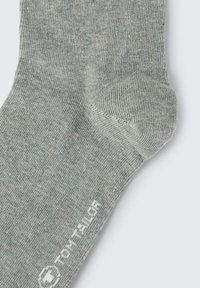 Graue Baumwollsocke mit glatter Textur, verstärkter Ferse und weißem Markenzeichen an der Seite. Klassisches Design, das sich für Freizeitkleidung eignet.