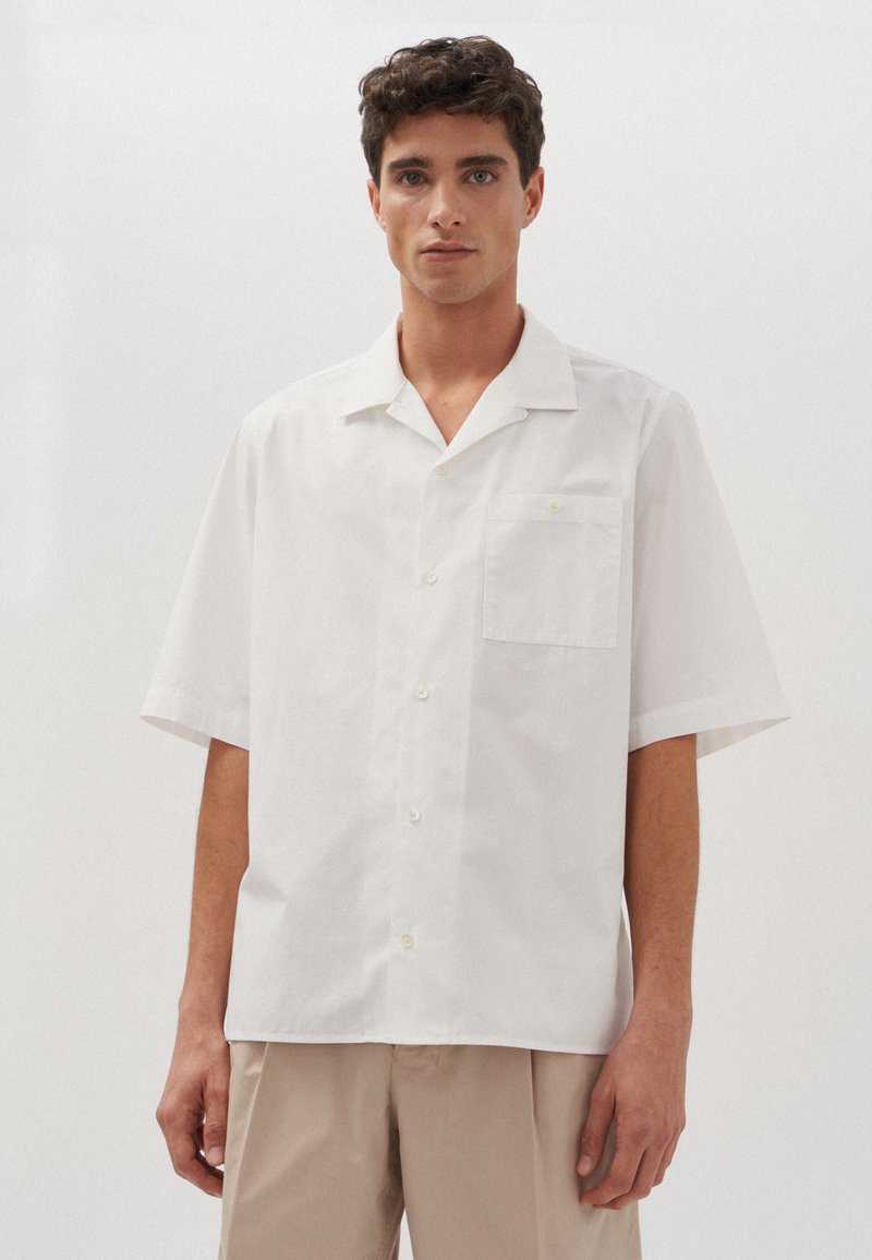 Witte shirt met korte mouwen, een camp collar, een borstzak en knoopsluiting. Gemaakt van gladde stof met een minimalistisch ontwerp.