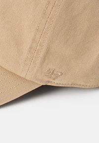 Beige kordbársony sapka strukturált formával. Tonális varrásokkal és diszkrét "47" hímzéssel az oldalon.