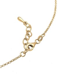 Collier en chaîne dorée avec un fermoir à ressort et des maillons réglables sur fond blanc.