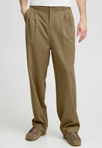 Belted herenbroek in tan stof, met twee voorplooien, zijzakken en een recht model. Zachte textuur met een perfecte pasvorm.