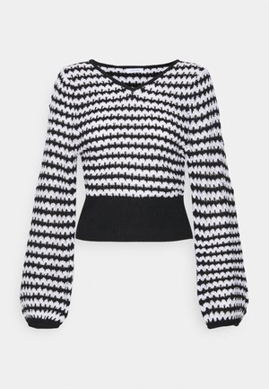 Pull en maille à rayures noires et blanches avec manches longues bouffantes, taille côtelée ajustée et col en V.